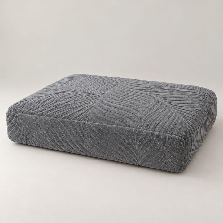 Gray leaf jacquard cover being smoothed over a deep seat cushion